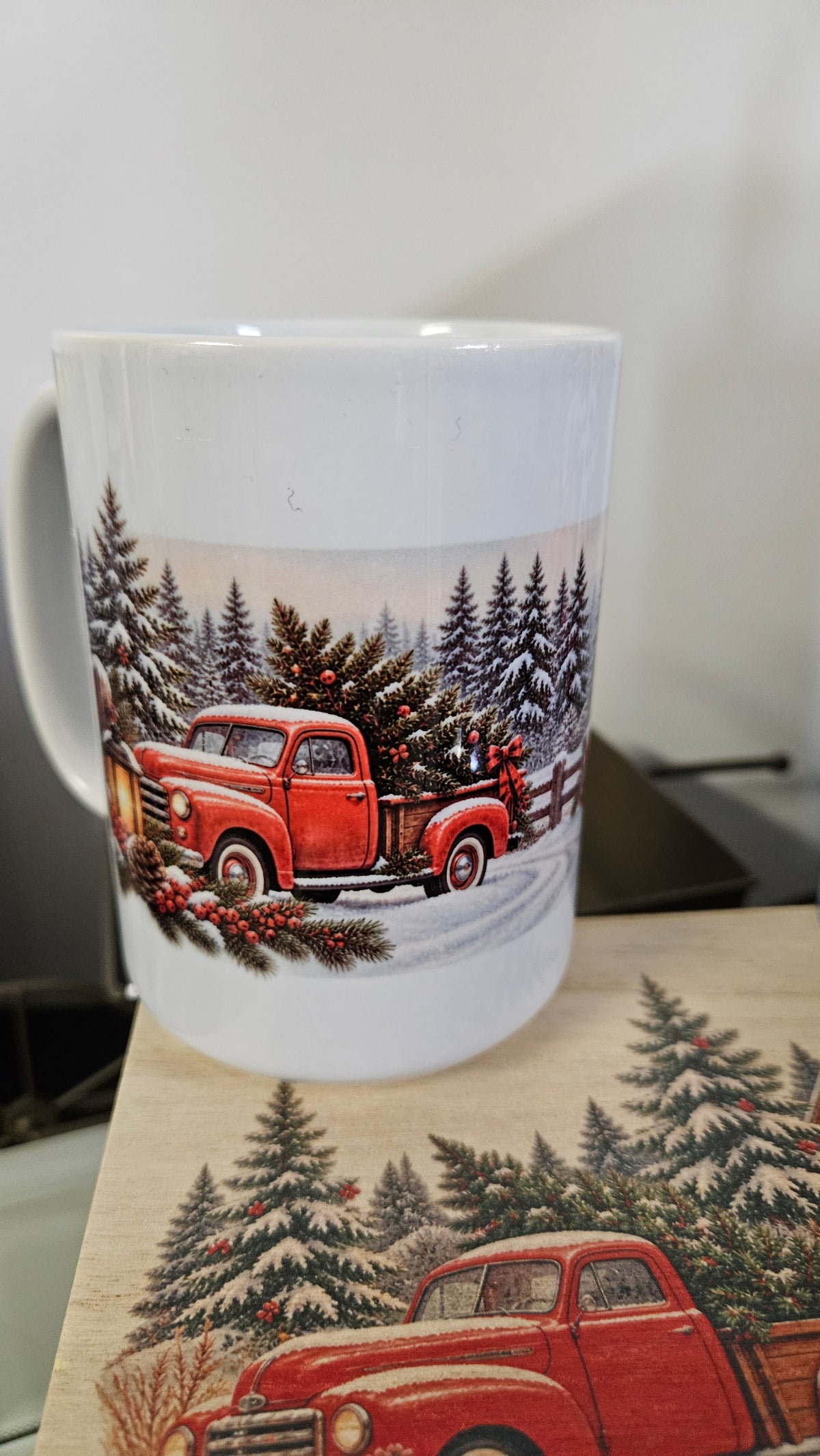 Christmas mug with a vintage red truck carrying a tree through snowy pines